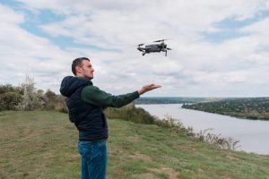 Young man piloting a drone in nature